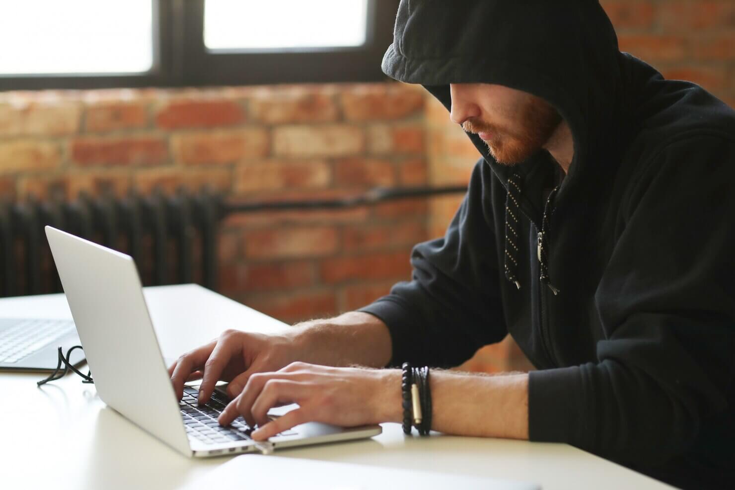 Man working on laptop to boost WordPress security with Two-factor authentication