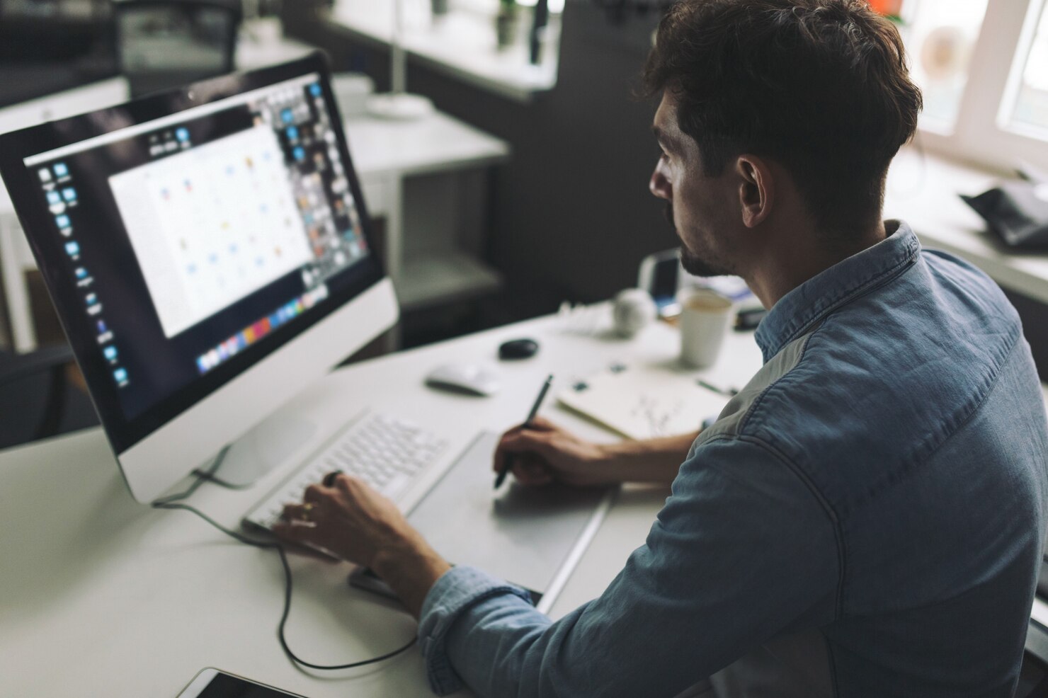 Young graphic designer working in office. Creating a design based on quantitative data to increase conversions