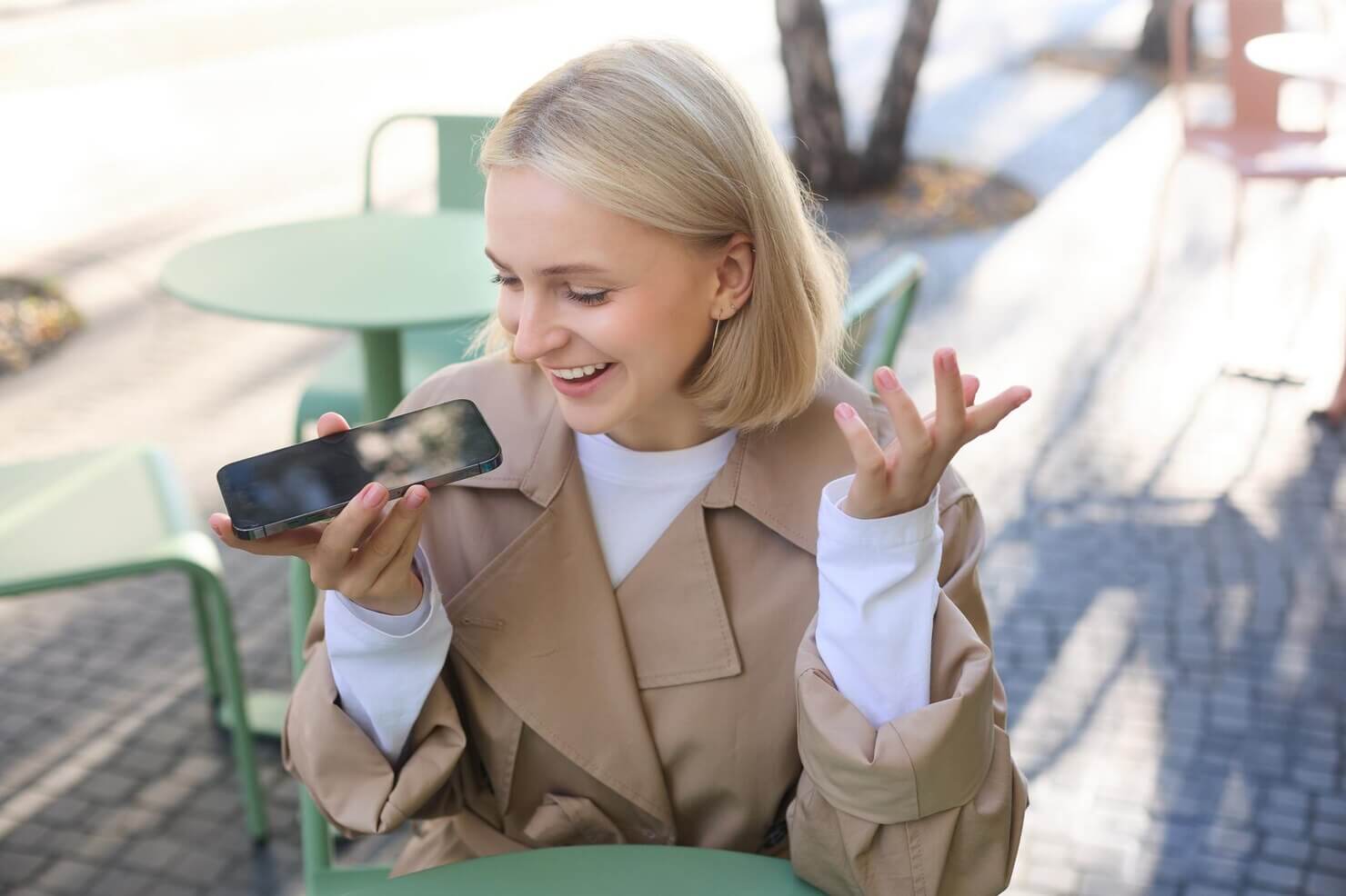 Young woman using mobile device while outside at a cafe