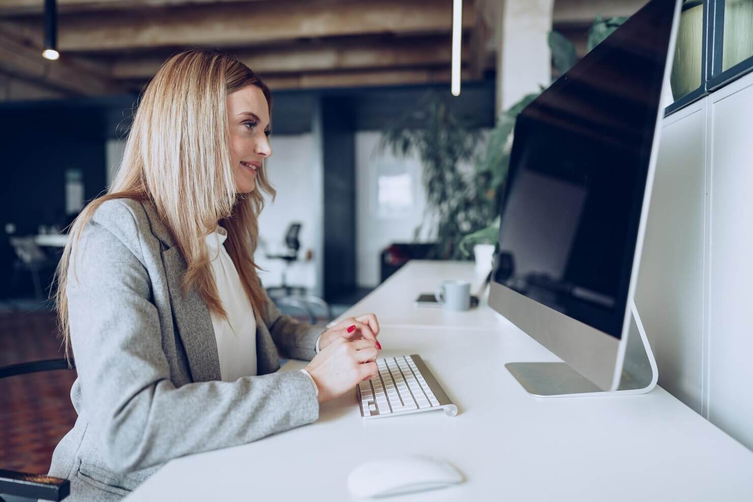 Businesswoman sitting at her working table in office researching about balancing aesthetics and usability in web design