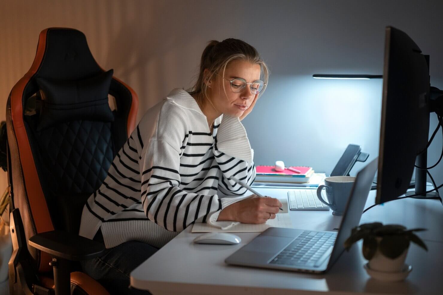 Woman working late at night to create a list of pros and cons for WordPress and Joomla