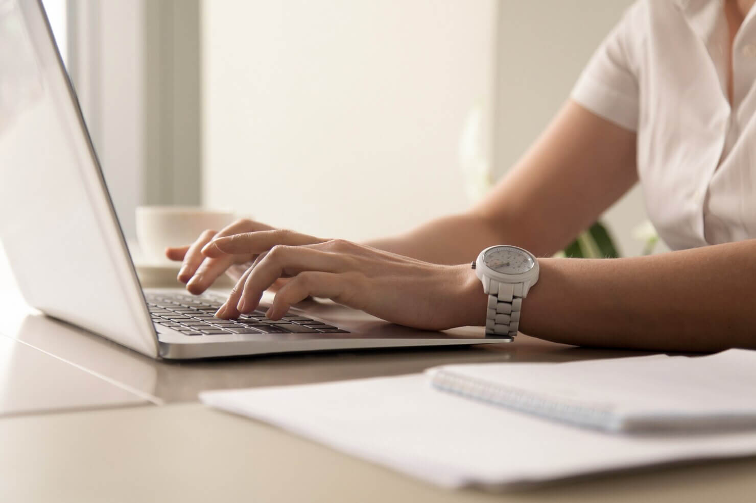 Womans hands typing on laptop at workplace to improve SEO on website as part of unlimited WP support
