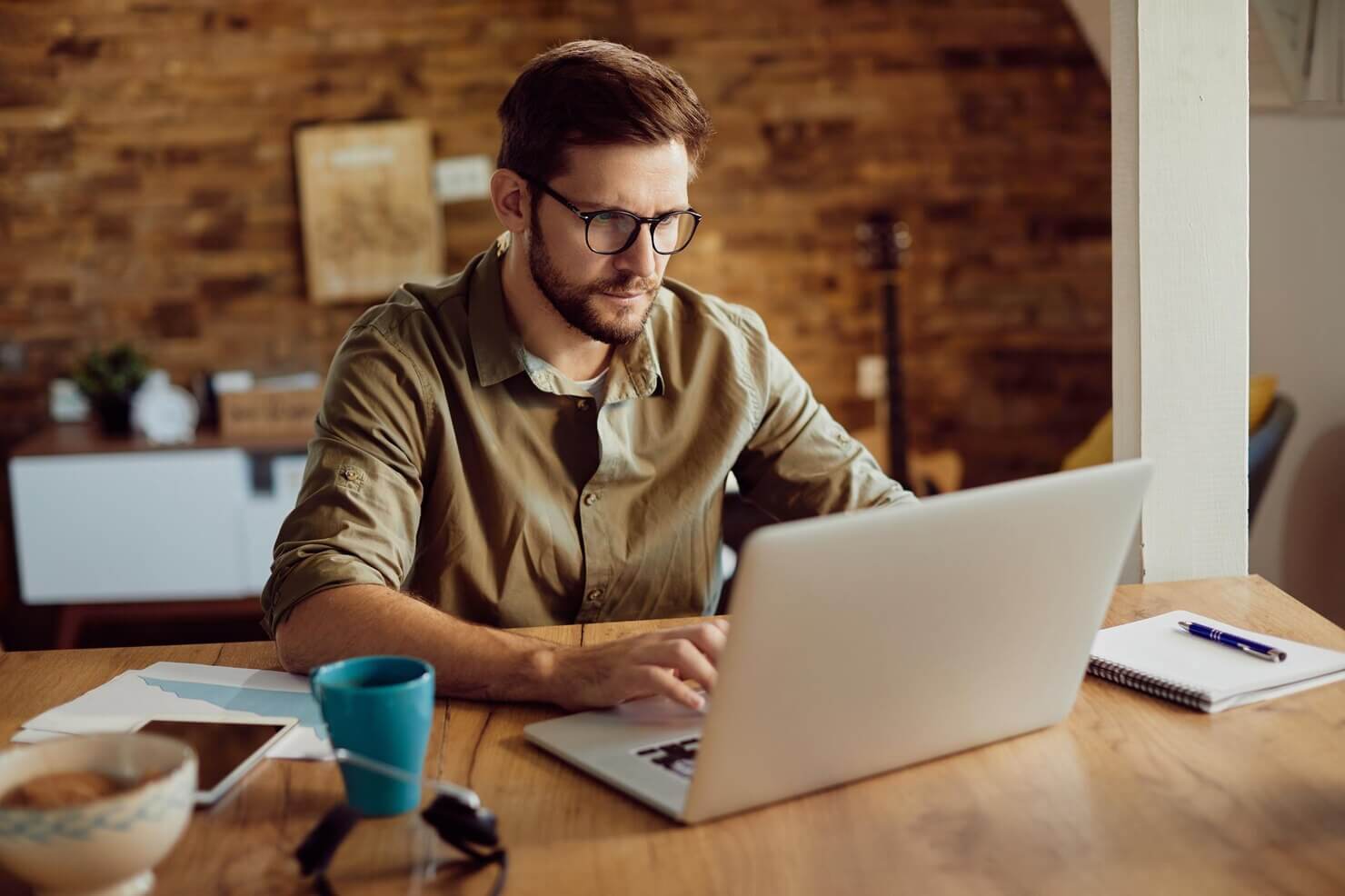 Male entrepreneur working on a computer at home learning about WordPress development strategies for marketing and advertising agencies