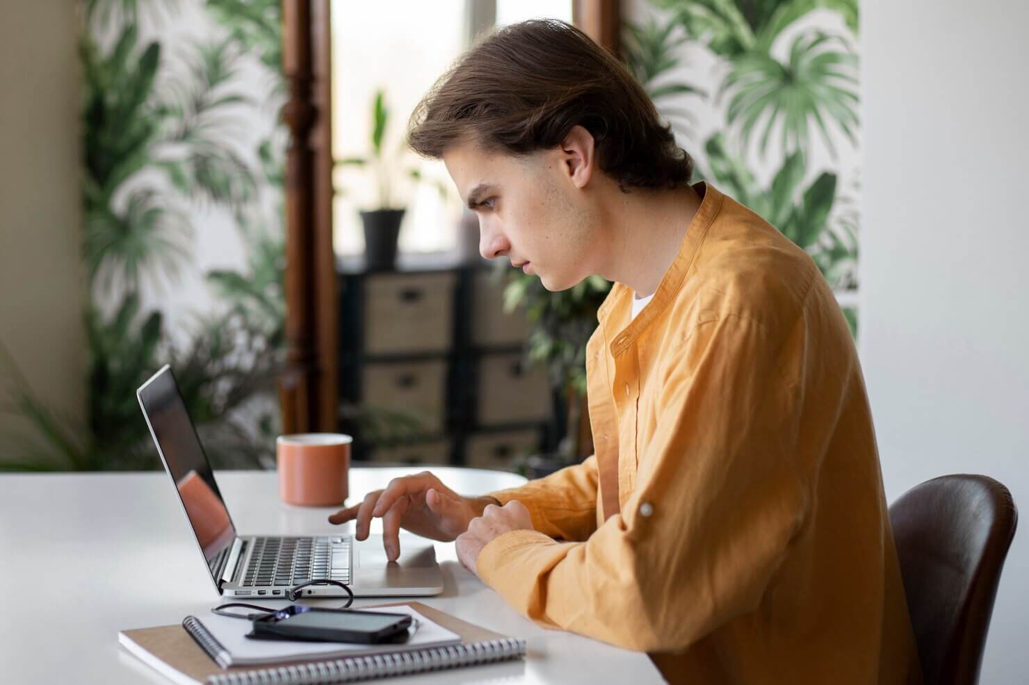 Man using laptop to do research on how to avoid mistakes in WooCommerce store with unlimited support