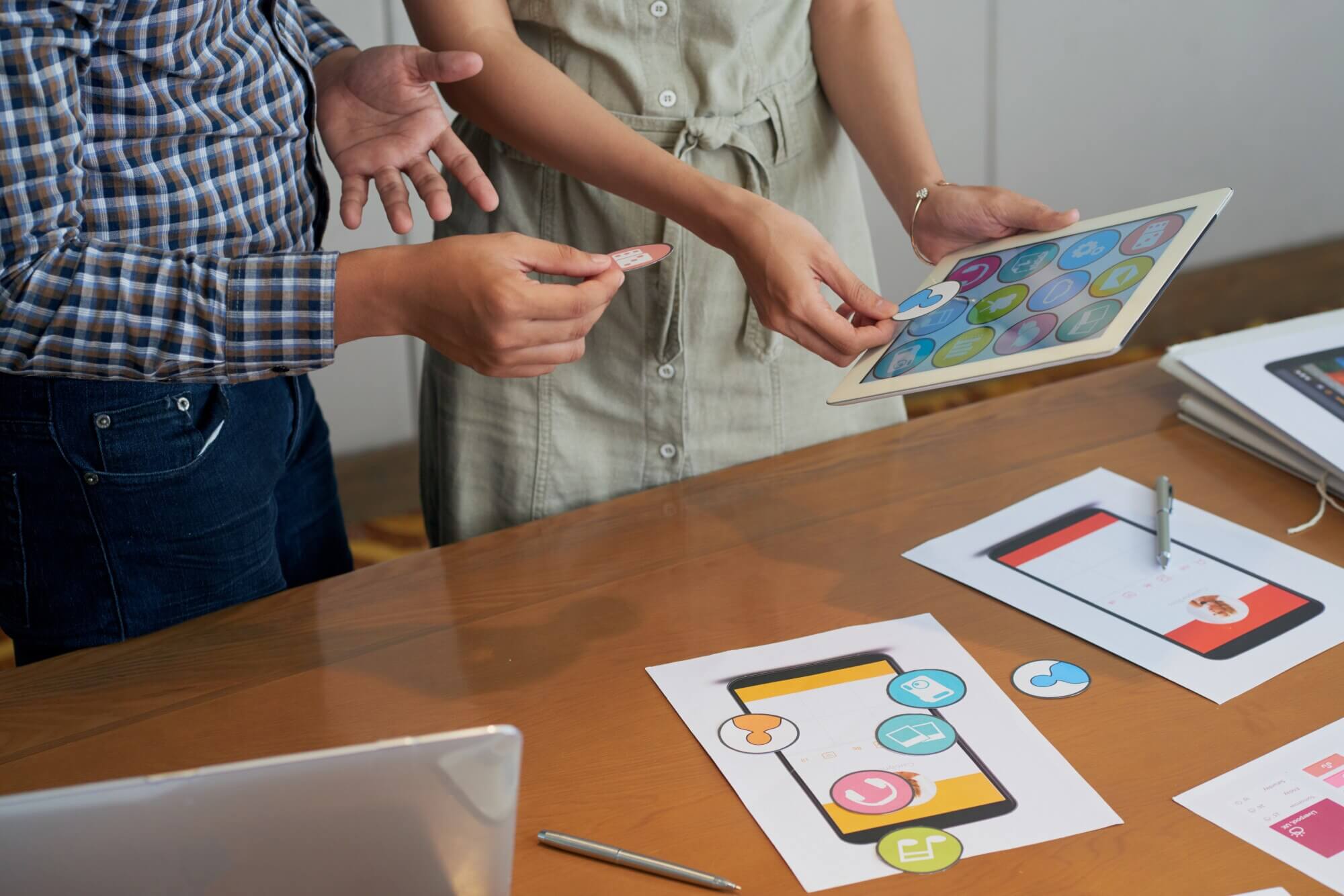 Colleagues looking at tablet and trying different icons to create a new mobile navigation