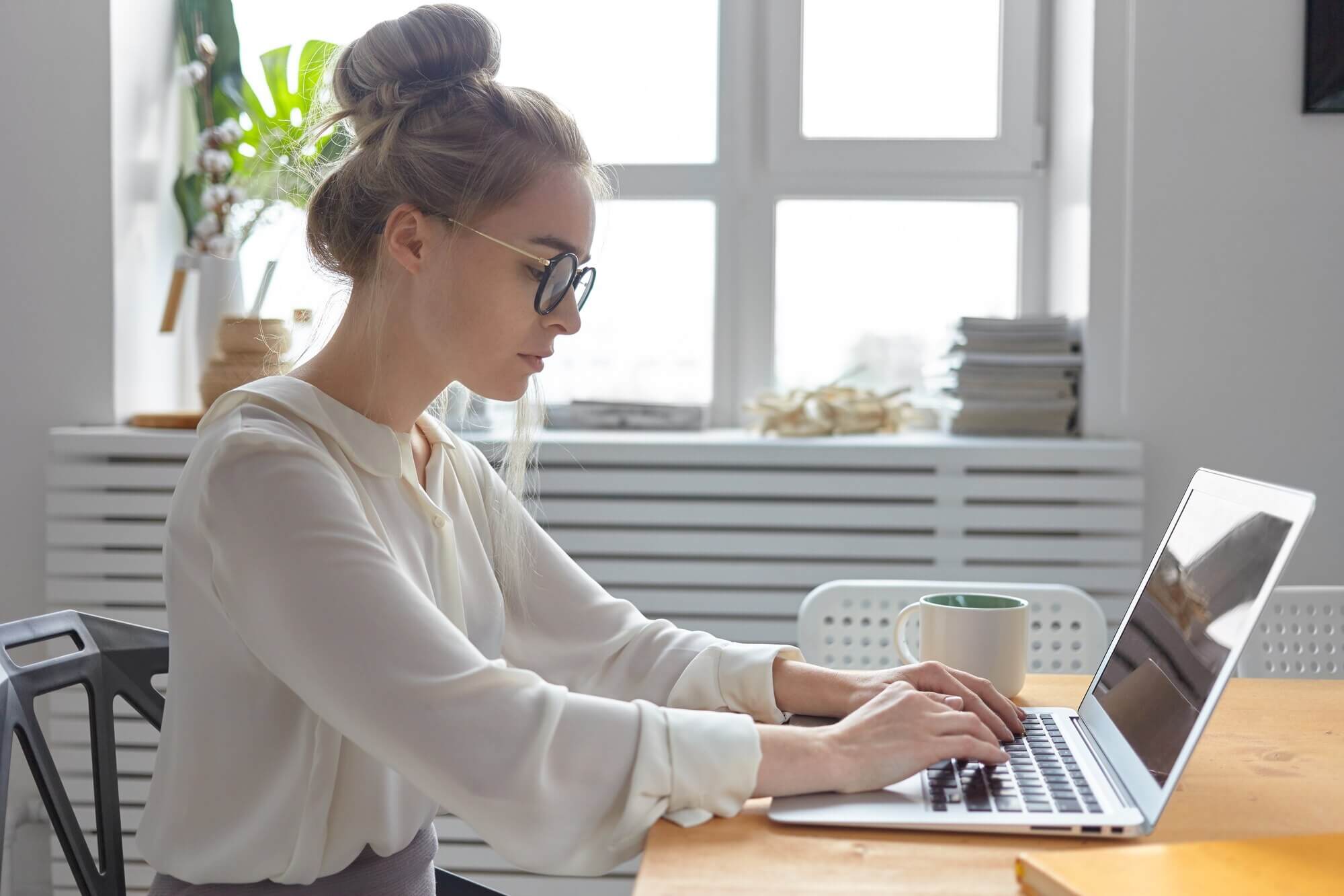 Female working on laptop writing report about the dark side of page builders