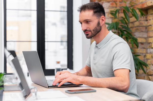 Close-up-on-young-businessman-writing-report-on-laptop-about-how-Unlimited-WordPress-support-can-help you stay ahead of competitors